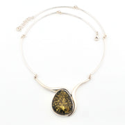 Necklace with a large teardrop-shaped green stone pendant on a white background