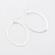 Pair of silver hoop earrings on a light gray background