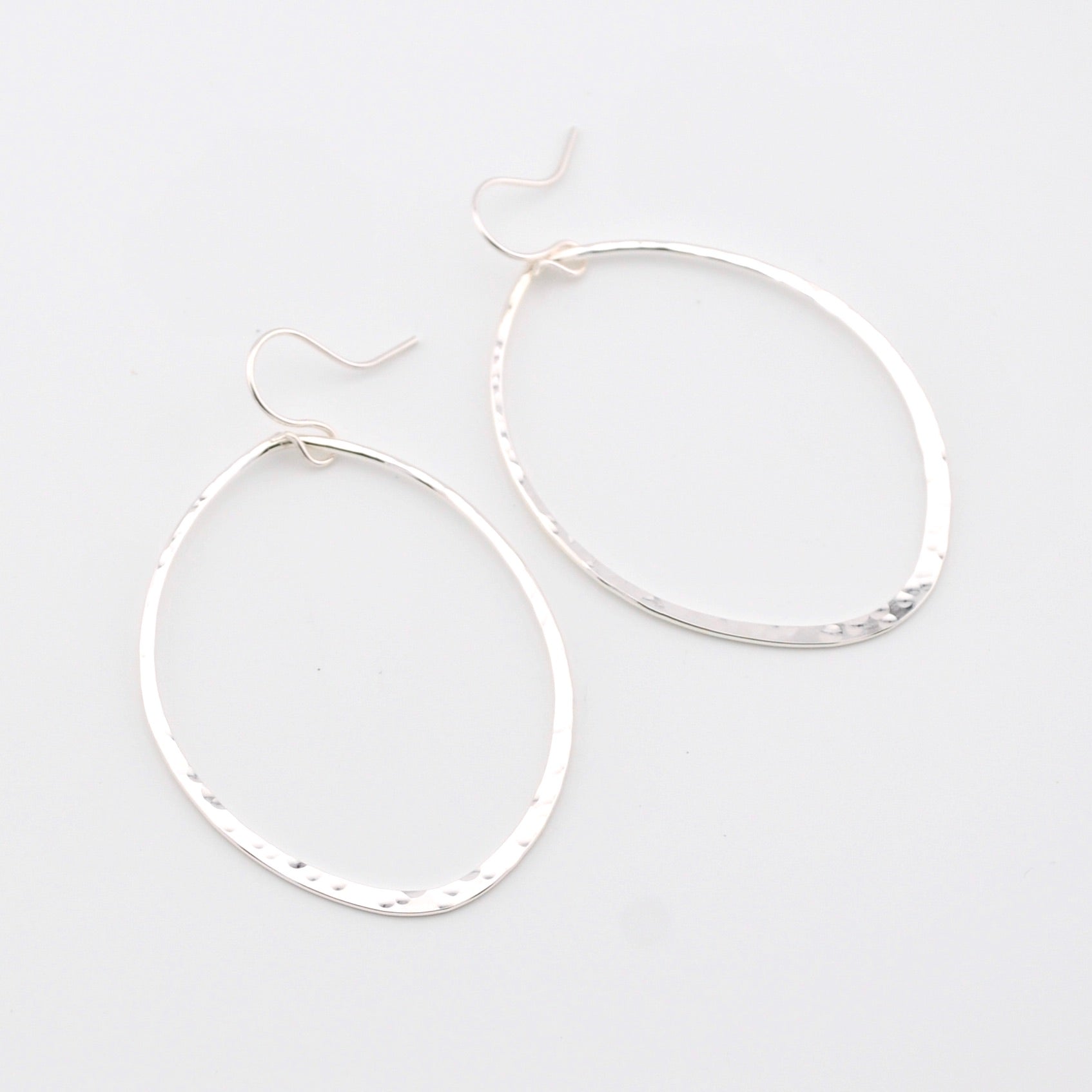 Pair of silver hoop earrings on a light gray background