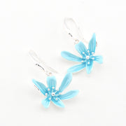 Pair of light blue flower-shaped earrings on a white background