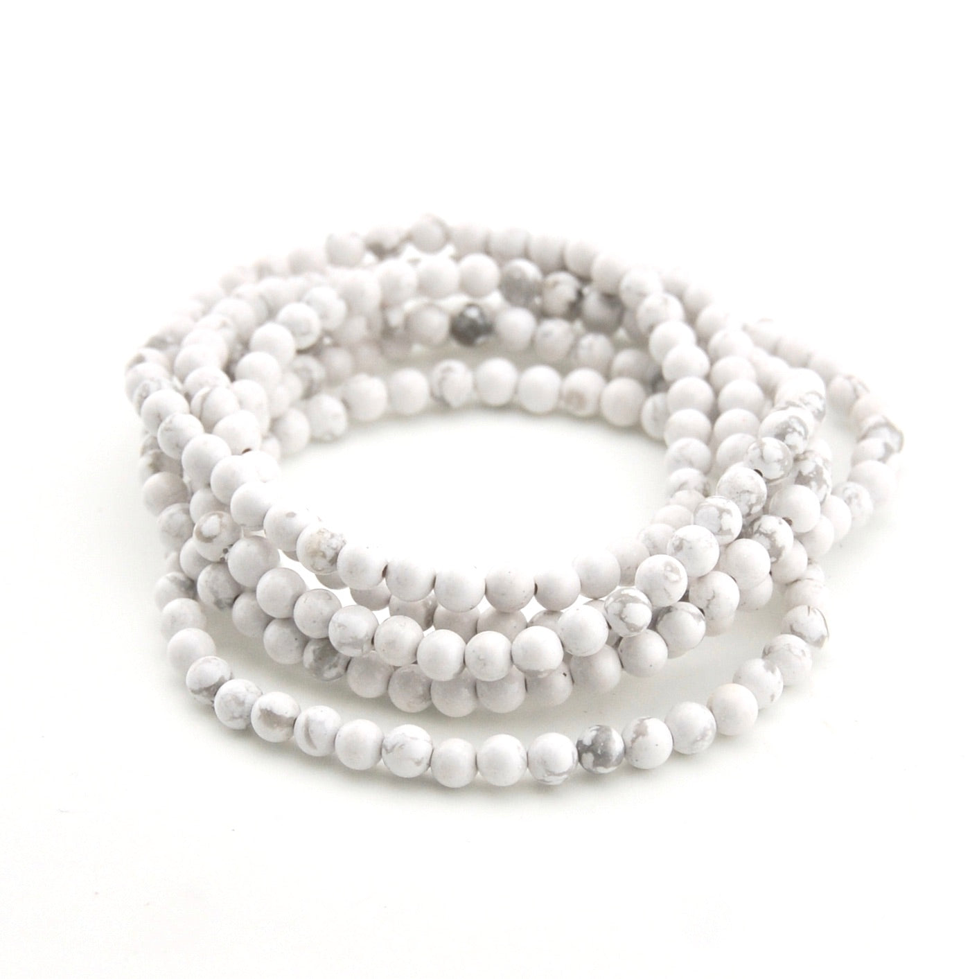 Stack of white beaded bracelets on a white background