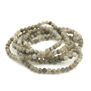 Beaded necklace with gray and white stones on a white background