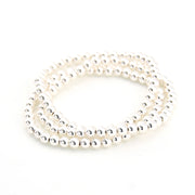 Stack of silver bracelets on a white background