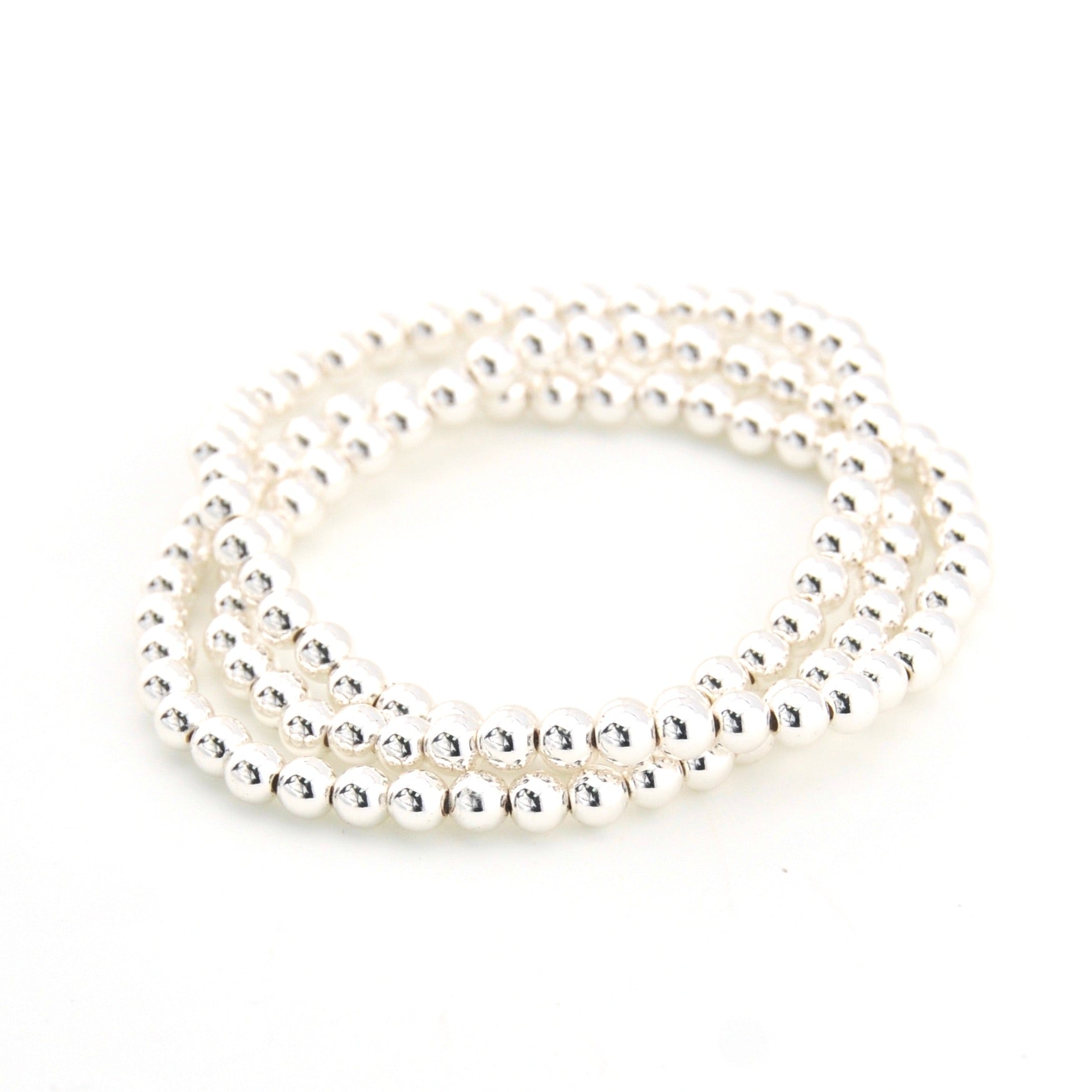 Stack of silver bracelets on a white background