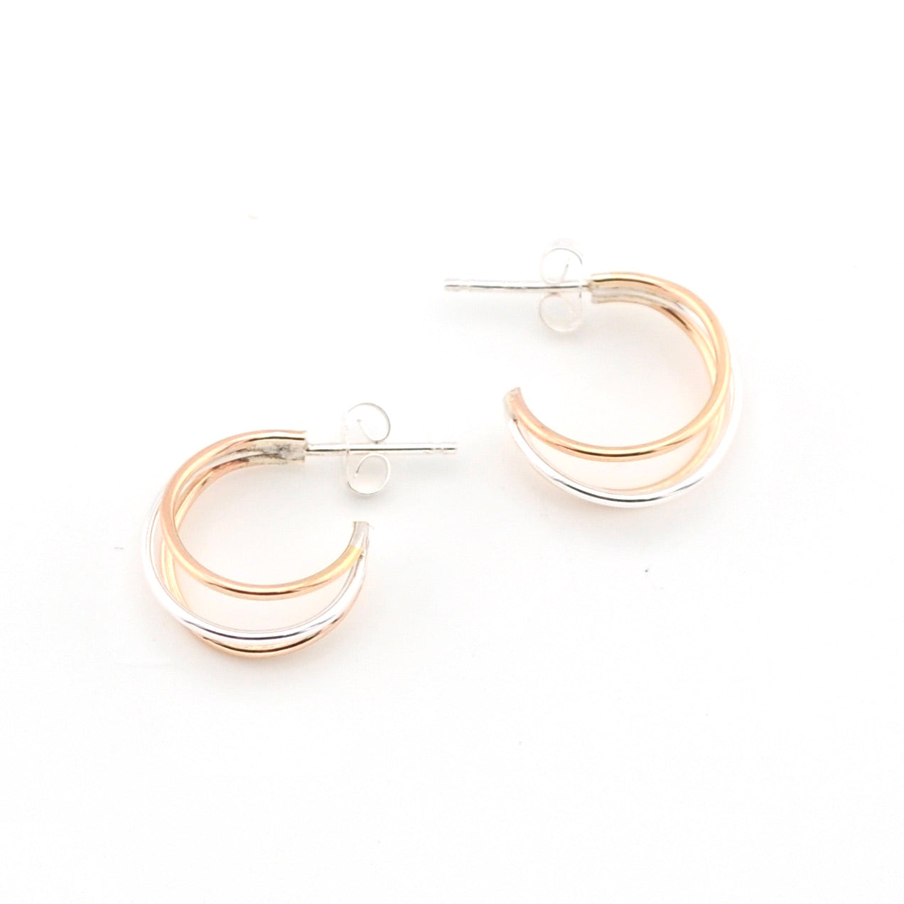 Pair of gold and silver hoop earrings on a white background