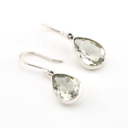 Teardrop-shaped green gemstone earrings on a white background