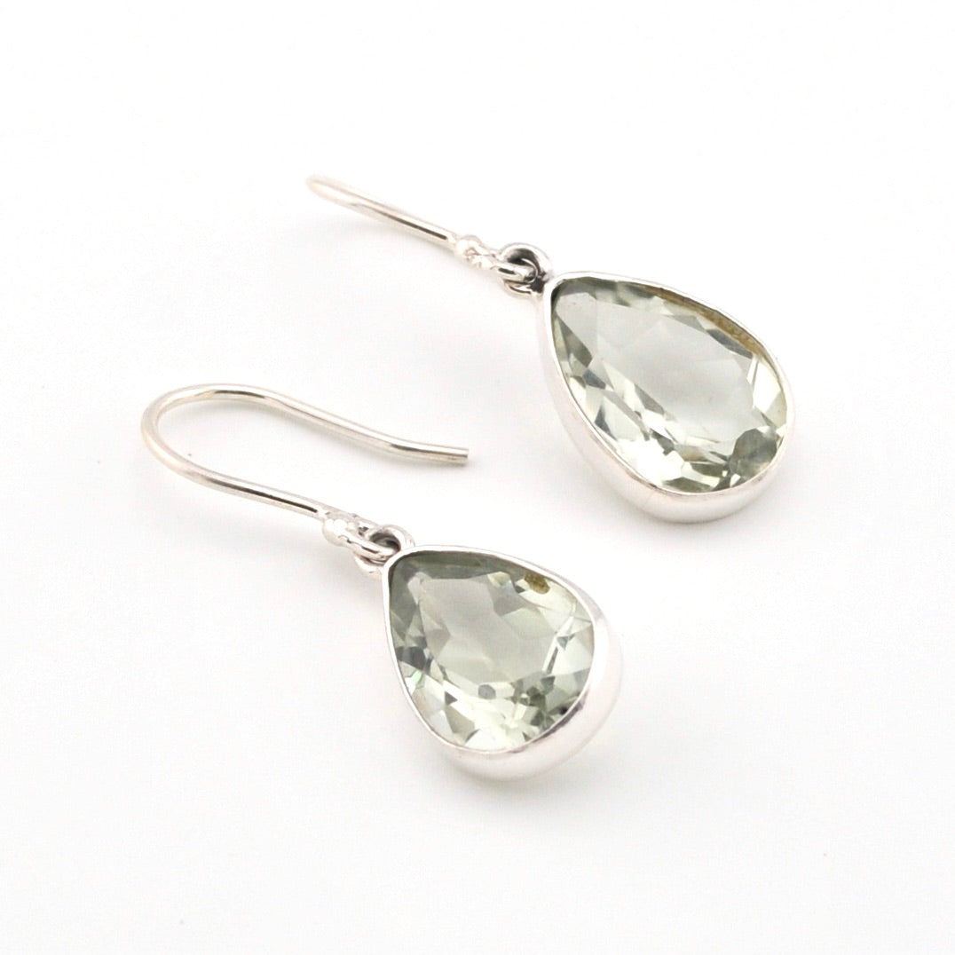 Teardrop-shaped green gemstone earrings on a white background