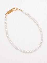Pearl bracelet with a gold clasp on a white background