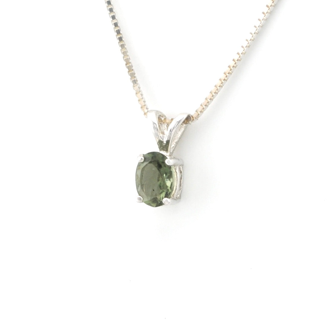 An oval-cut green gemstone pendant in a silver-toned setting, suspended from a delicate silver chain against a plain white background.