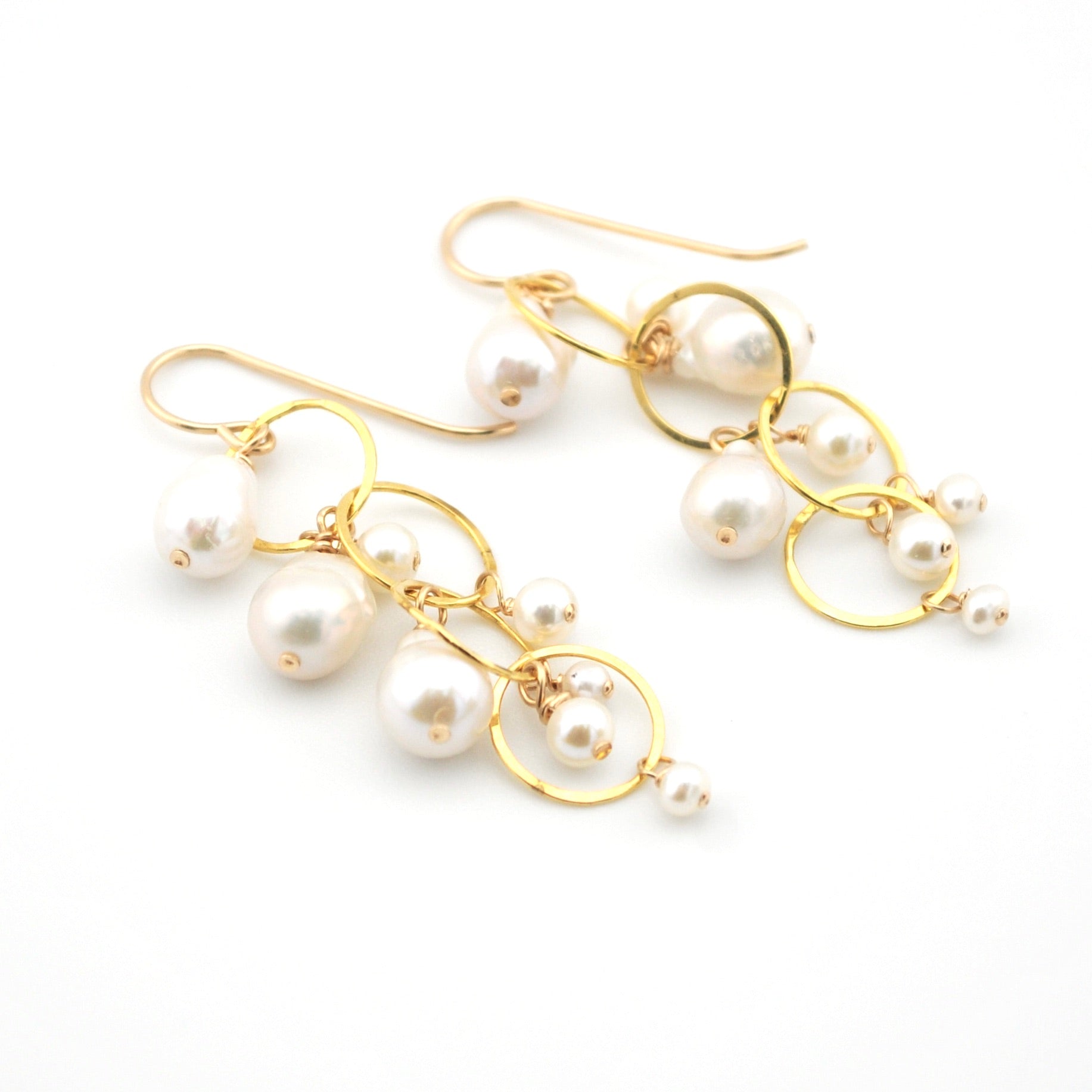 Pair of pearl earrings with gold hooks on a white background