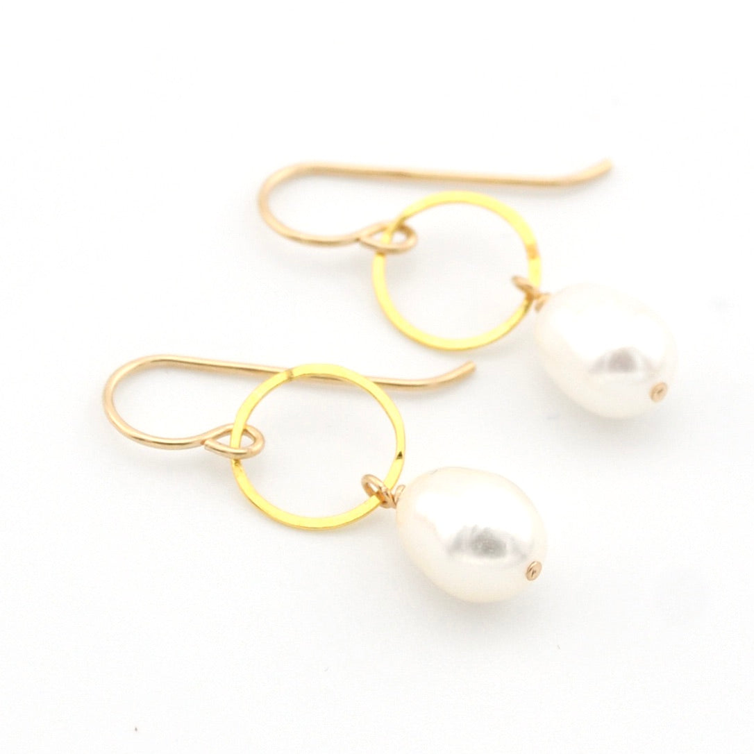Gold hoop earrings with pearls on a white background