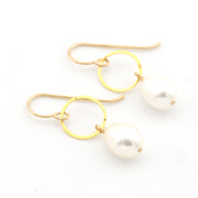 Gold hoop earrings with pearls on a white background