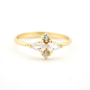 Gold ring with clear gemstones on a white background
