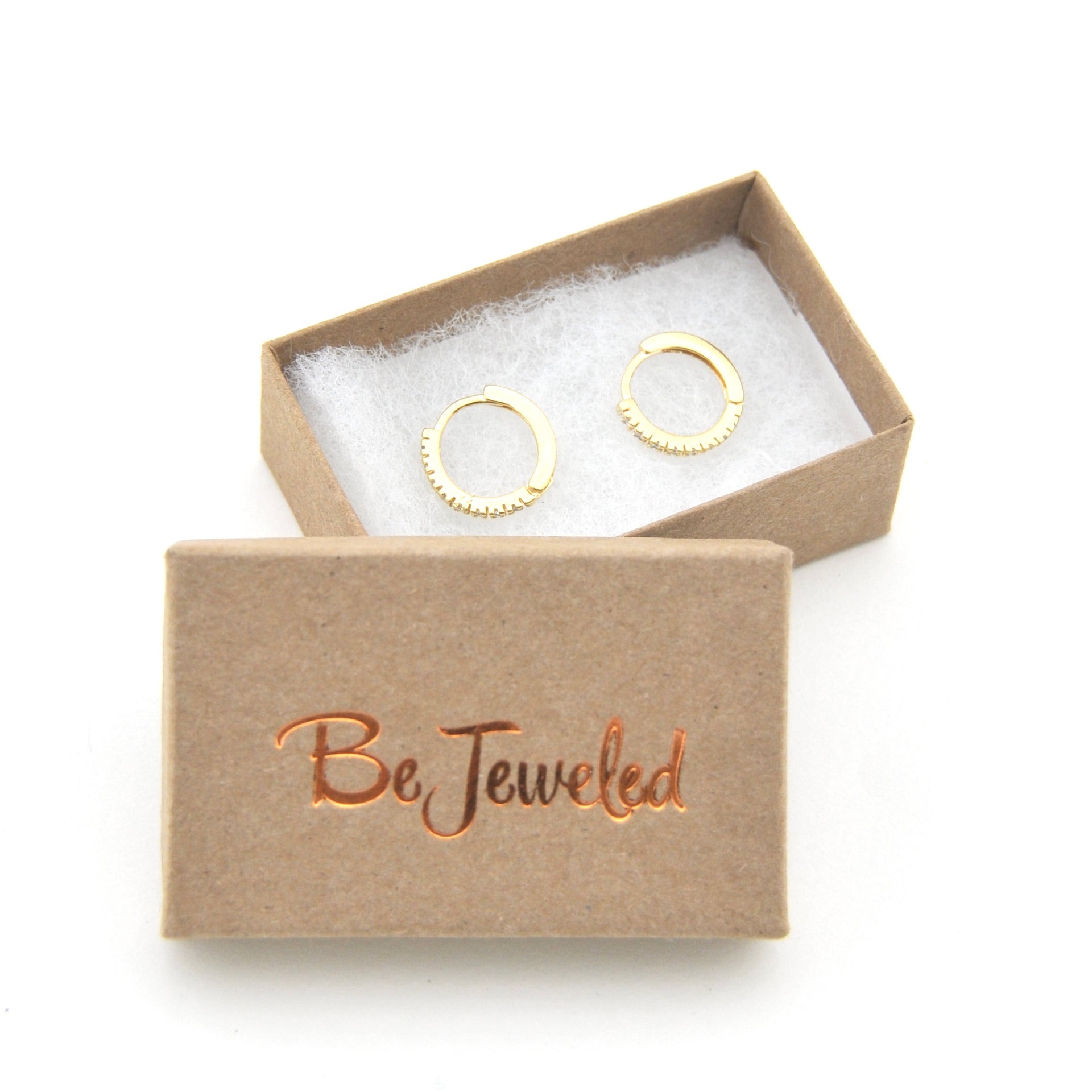Gold hoop earrings in a 'Be Jeweled' box on a white background