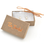 Gold earrings in a 'Be Jeweled' box on a white background