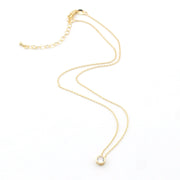 Gold necklace with a small pendant on a white background