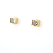 Gold square earrings with clear gemstones on a white background