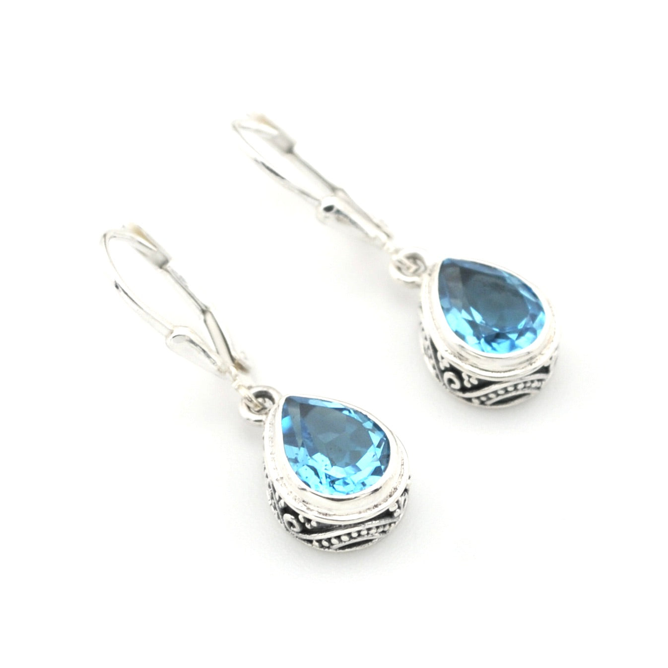Pair of silver earrings with blue gemstones on a white background