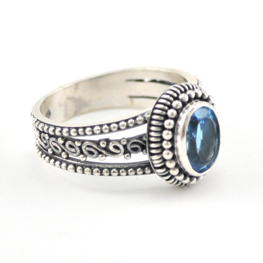 Side View Silver Blue Topaz 6x8mm Oval 3 Band Scroll Ring