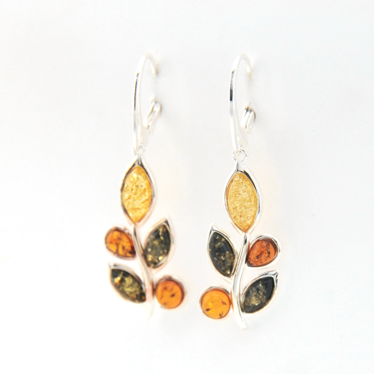 Pair of earrings with leaf-shaped amber stones on a white background