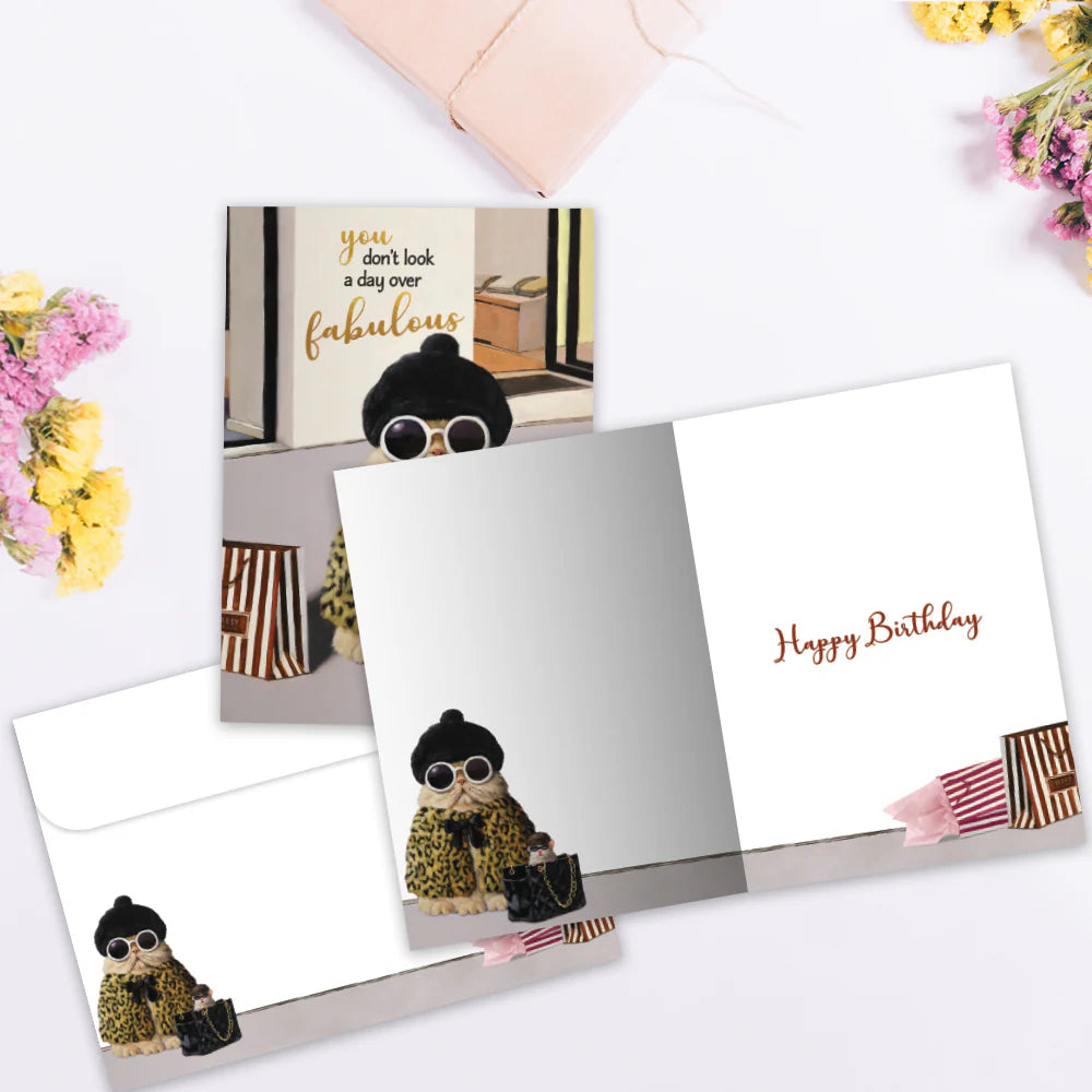Greeting card with a dog illustration and 'Happy Birthday' text on a white surface with flowers.