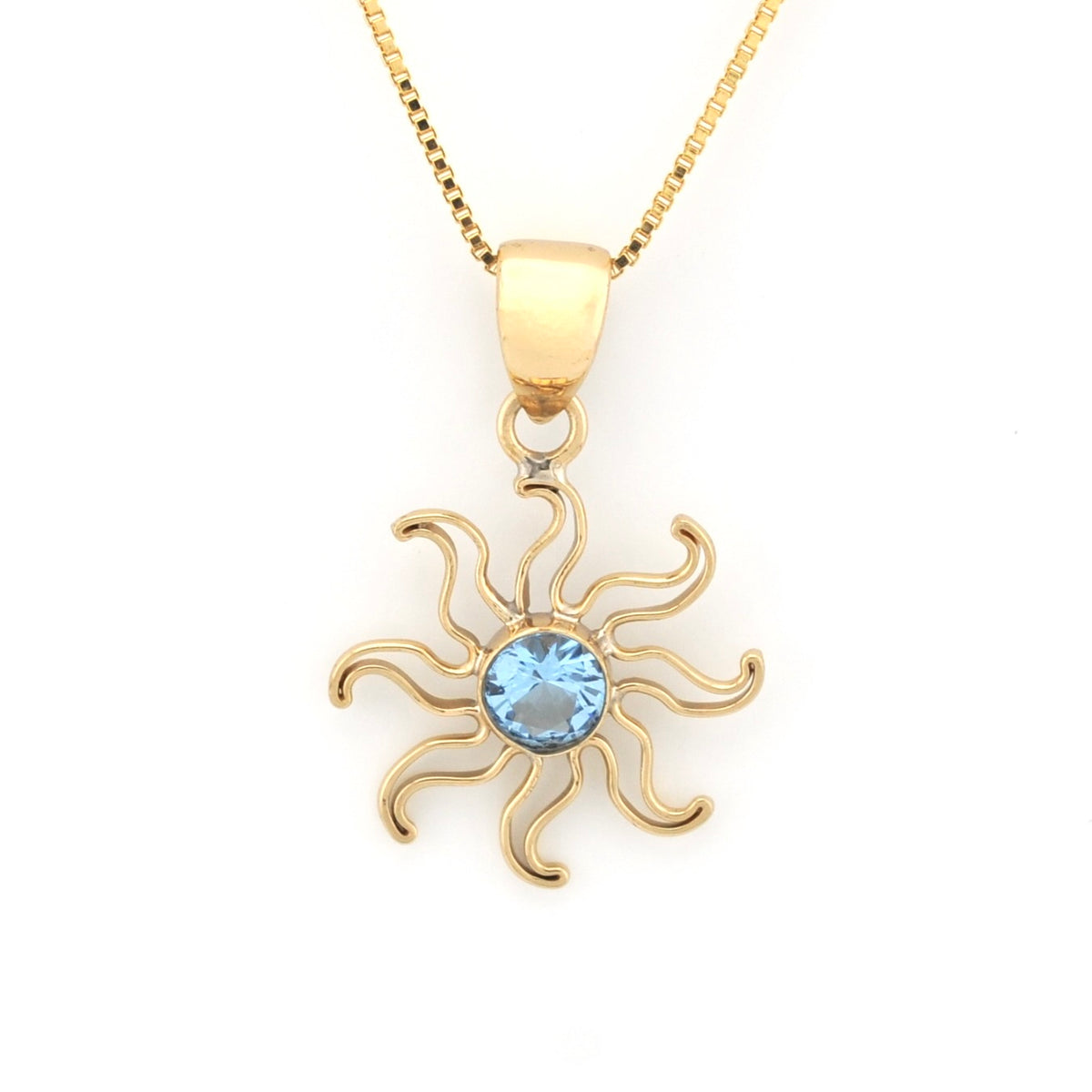 A gold pendant necklace featuring a stylized sun design with a round light blue gemstone in the center, suspended from a gold chain on a white background.