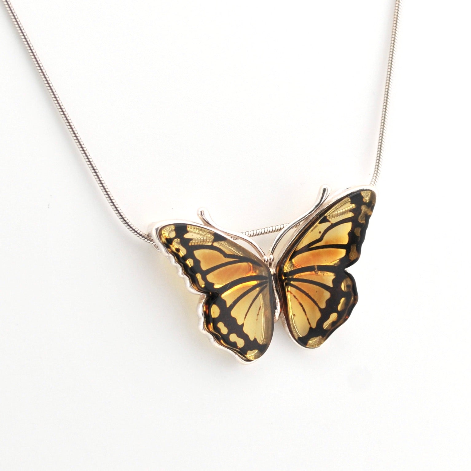 Butterfly-shaped pendant on a chain against a white background