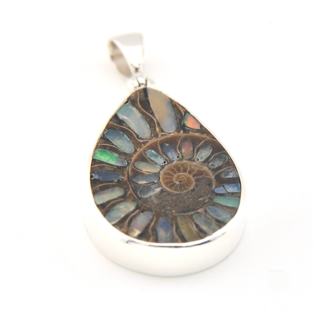 Teardrop-shaped pendant with multicolored stone and silver frame on a white background