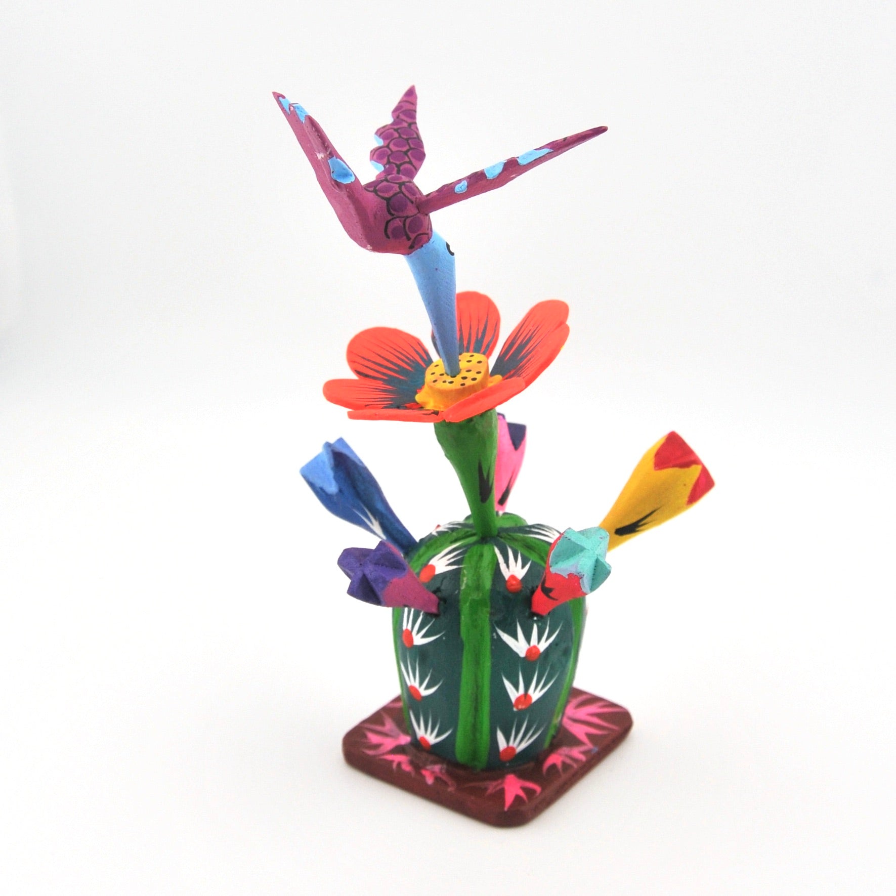 Colorful wood sculpture of a cactus with flowers and birds on a white background