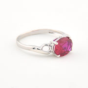Silver ring with a red gemstone on a white background