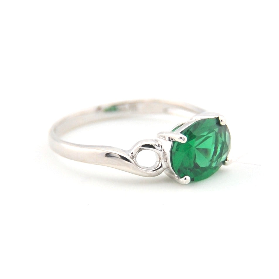 Silver ring with a green gemstone on a white background
