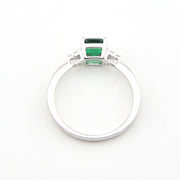Silver ring with green gemstones on a white background