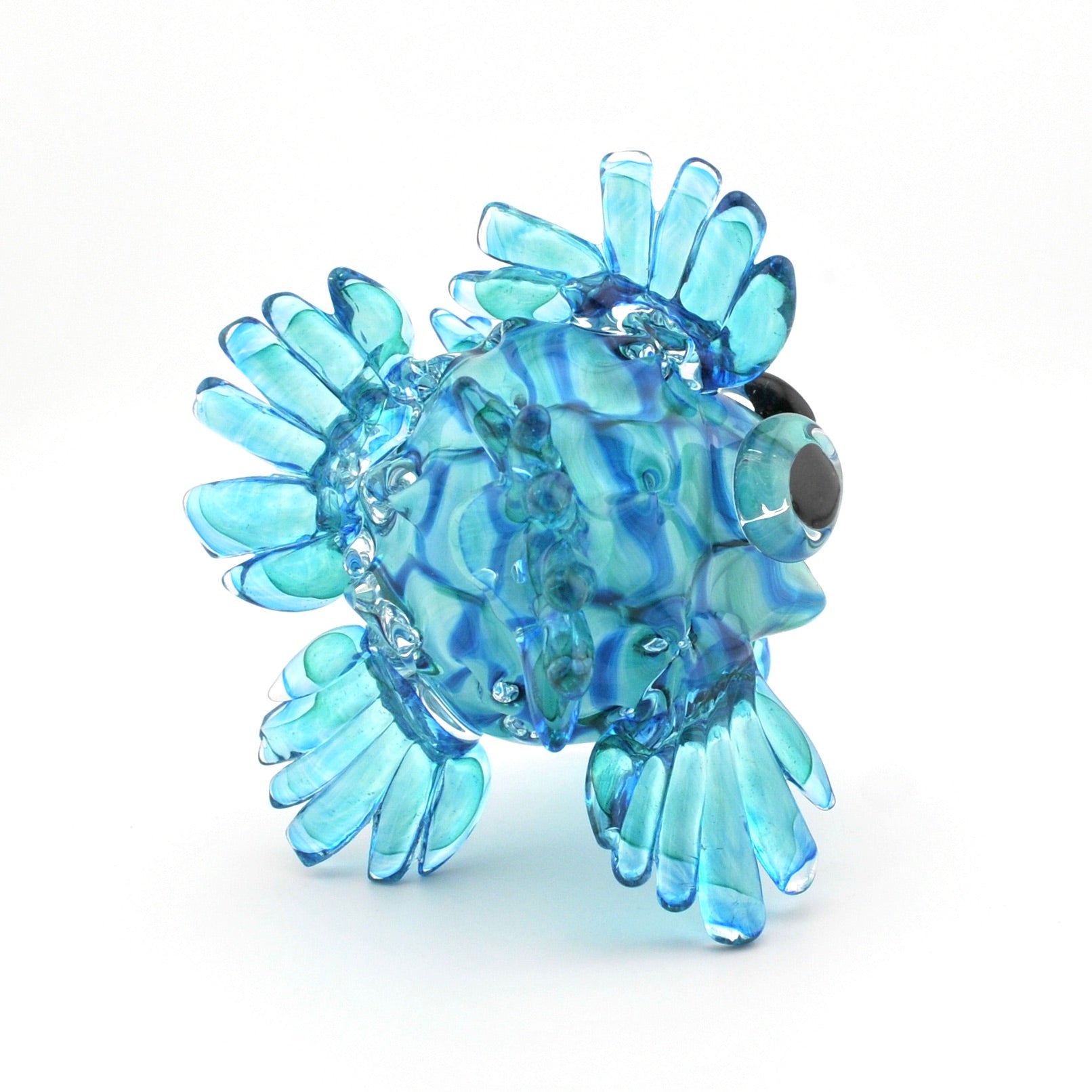 Glass fish figurine with blue and green swirl pattern on a white background