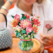 Colorful bouquet of flowers in a vase on a wooden table with a blurred background