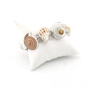 Bracelet with shell charms on a white pillow
