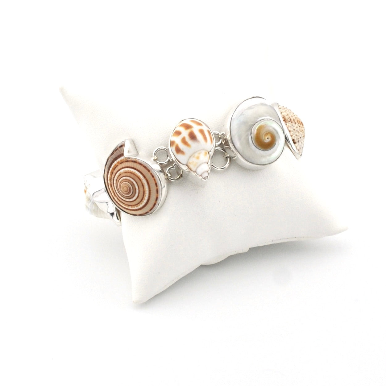 Bracelet with shell charms on a white pillow