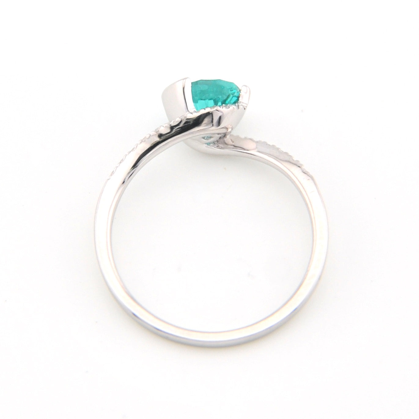 Silver ring with a green gemstone on a white background