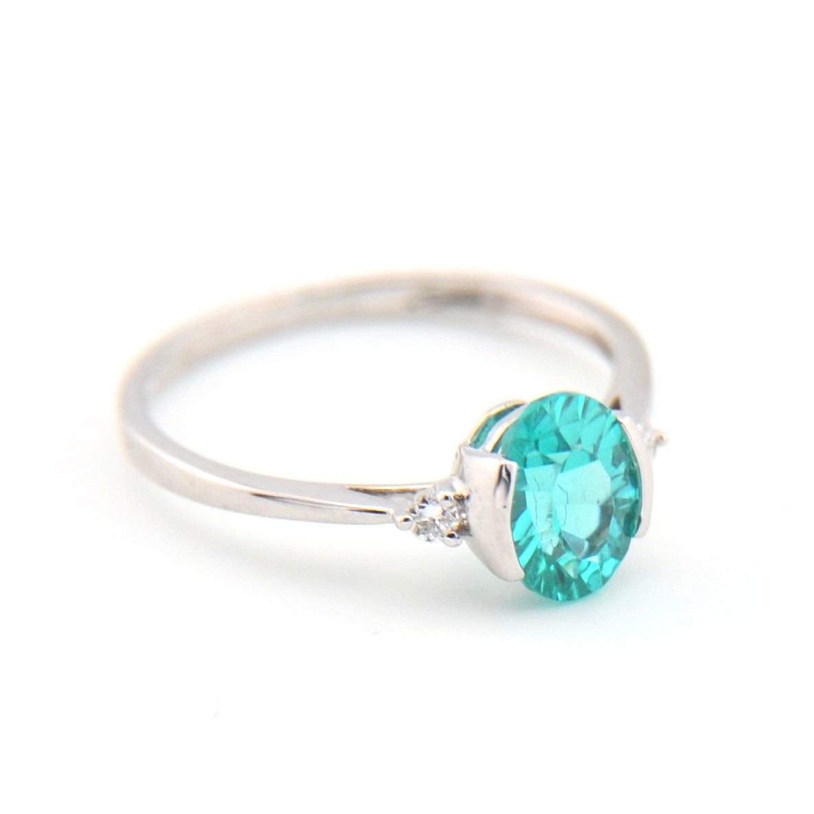 Silver ring with a teal gemstone on a white background