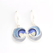Silver earrings with wave design on a white background