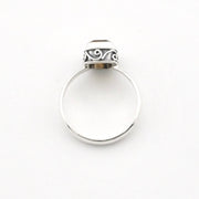 A silver ring with a polished circular band and a decorative textured cap, shown on a plain white background.