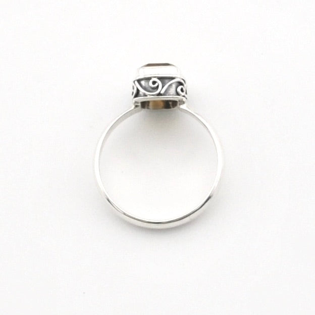 A silver ring with a polished circular band and a decorative textured cap, shown on a plain white background.