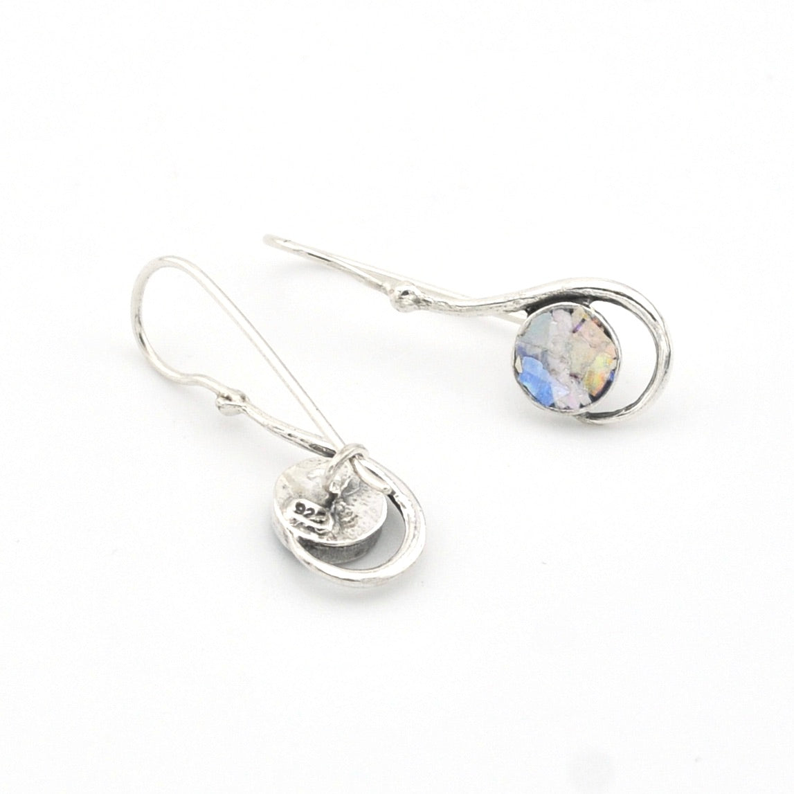 Silver earrings with a round gemstone on a white background