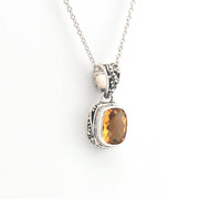 Silver pendant with a smoky quartz stone on a white background