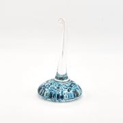 Glass ring holder with blue and white speckled design on a white background