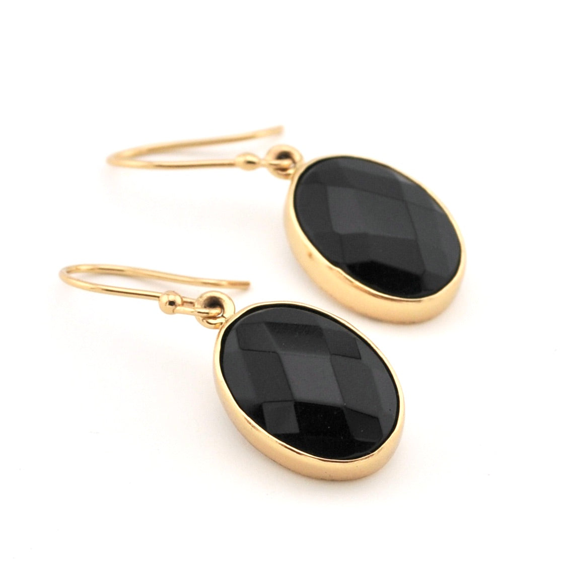 Gold earrings with black stones on a white background