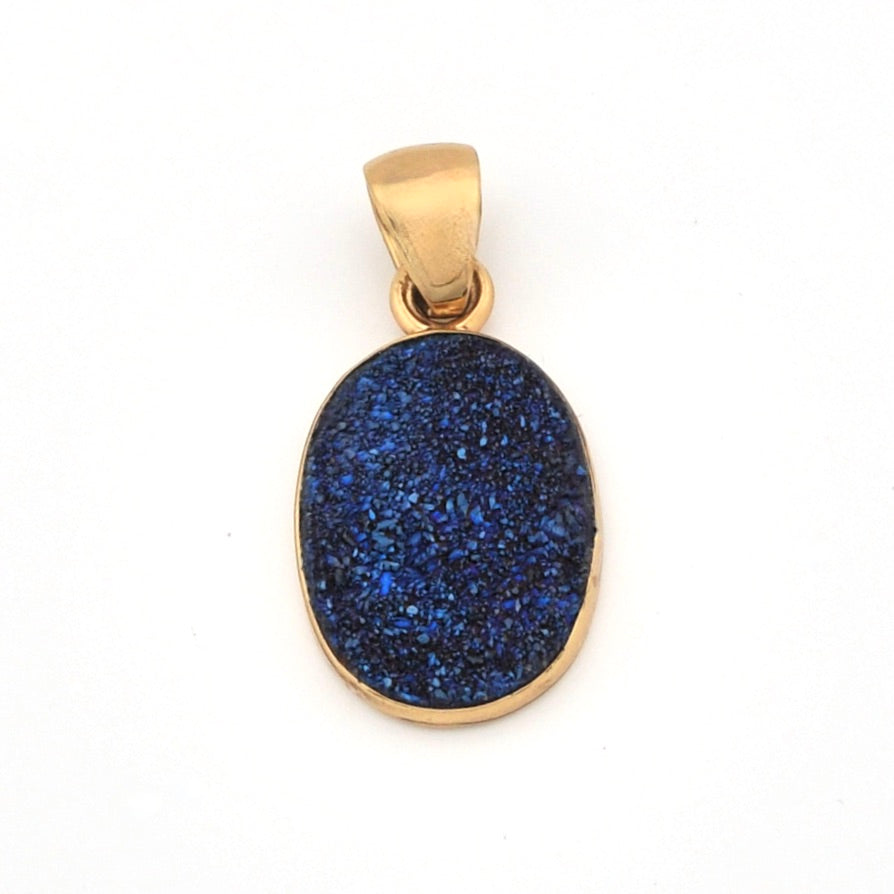 Gold pendant with a blue stone on a white background