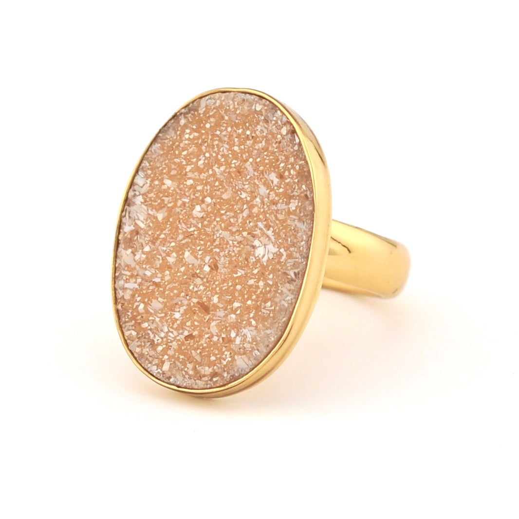 Gold ring with a beige stone on a white background