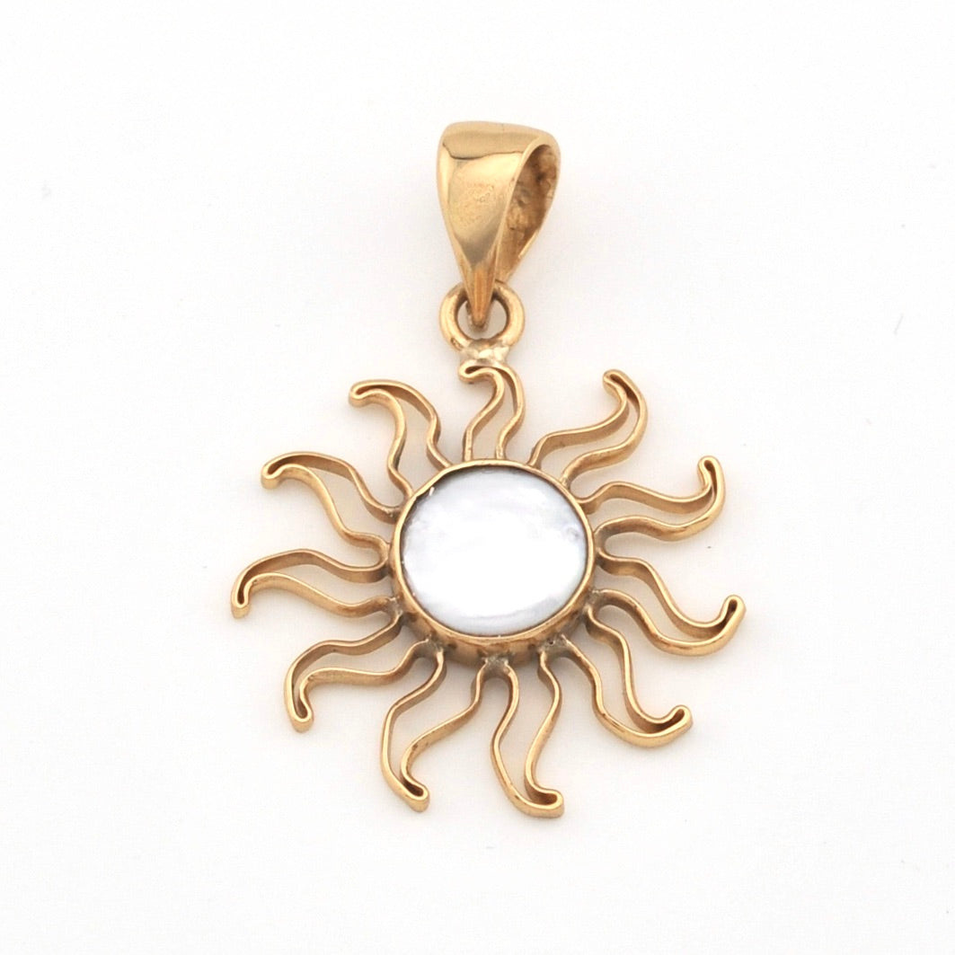 Gold sun-shaped pendant with a white center on a white background