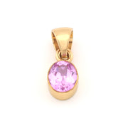 Gold pendant with a pink gemstone on a white background