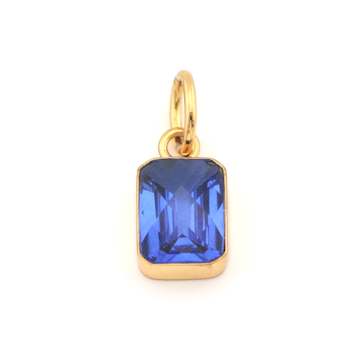 Gold pendant with a blue gemstone on a white background
